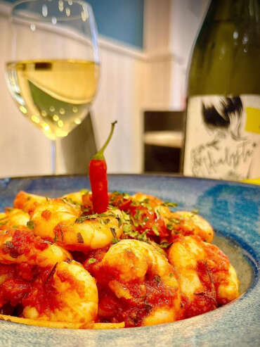 Plato de Gambas con guindillas con una copa de vino