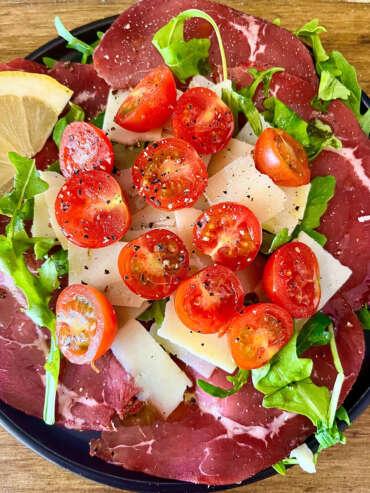 Ensalada de Jamón italiano y queso, decorado con tomates cherrys y rúcula