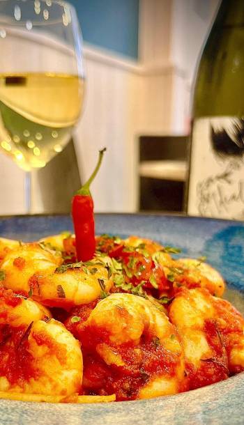 Plato de Gambas con guindillas con una copa de vino