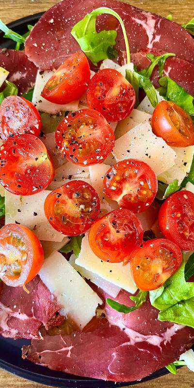 Ensalada de Jamón italiano y queso, decorado con tomates cherrys y rúcula